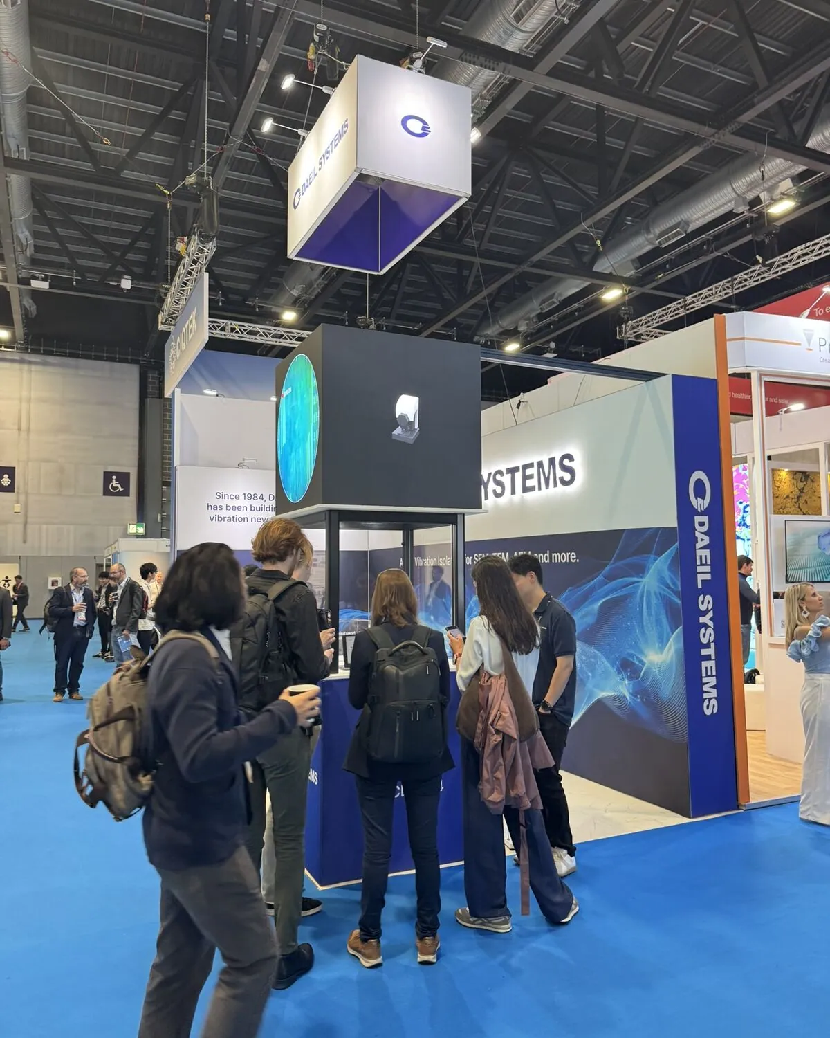 Visitors gather at the glass showcase under the LED video cube